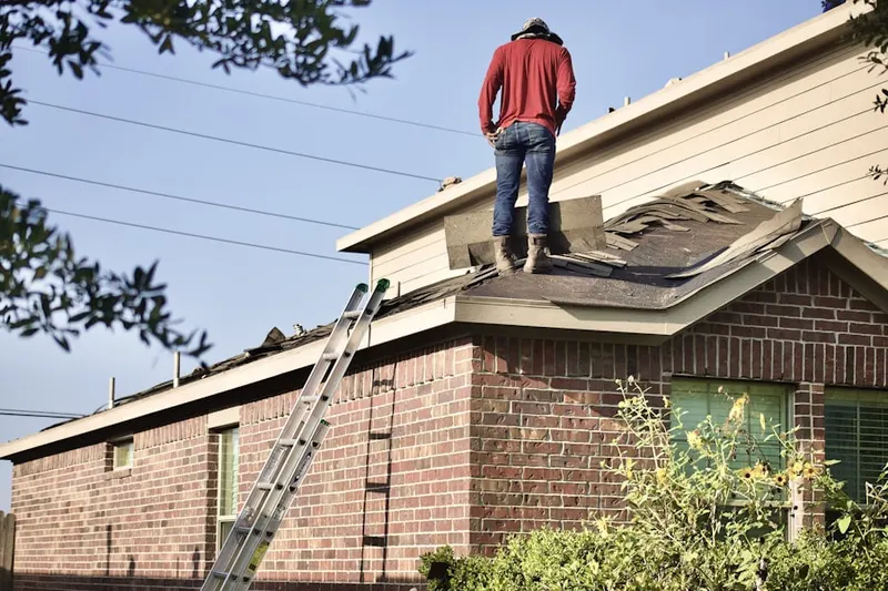 Professional roofer working on a residential roof in Shaker Village